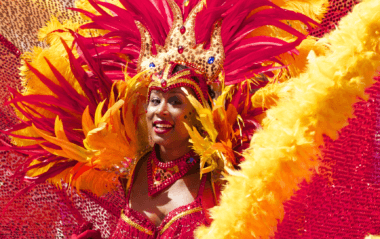 Young woman in a bright feathered carnival costume.